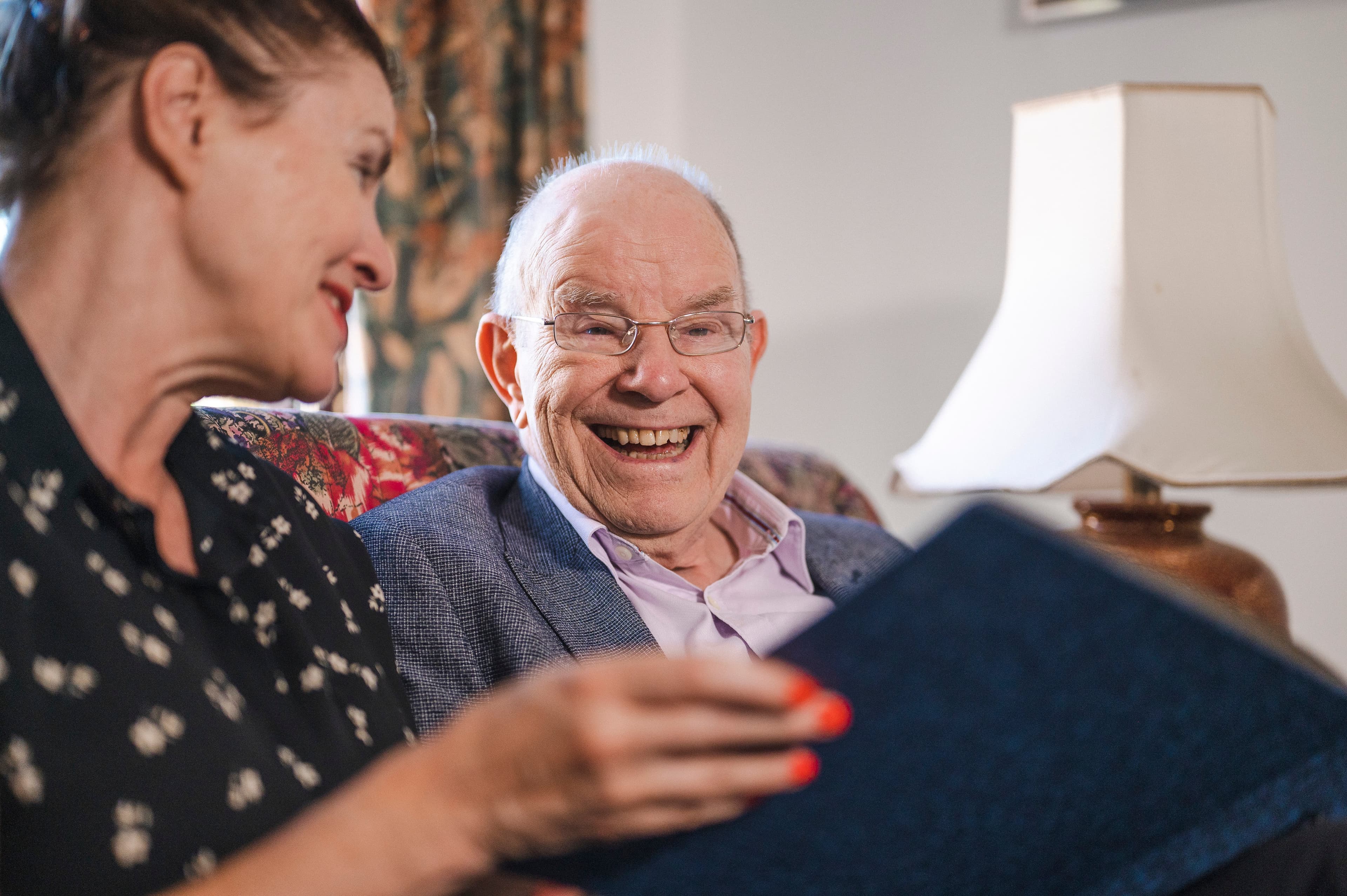 Caregiver preparing meals in client kitchen with senior