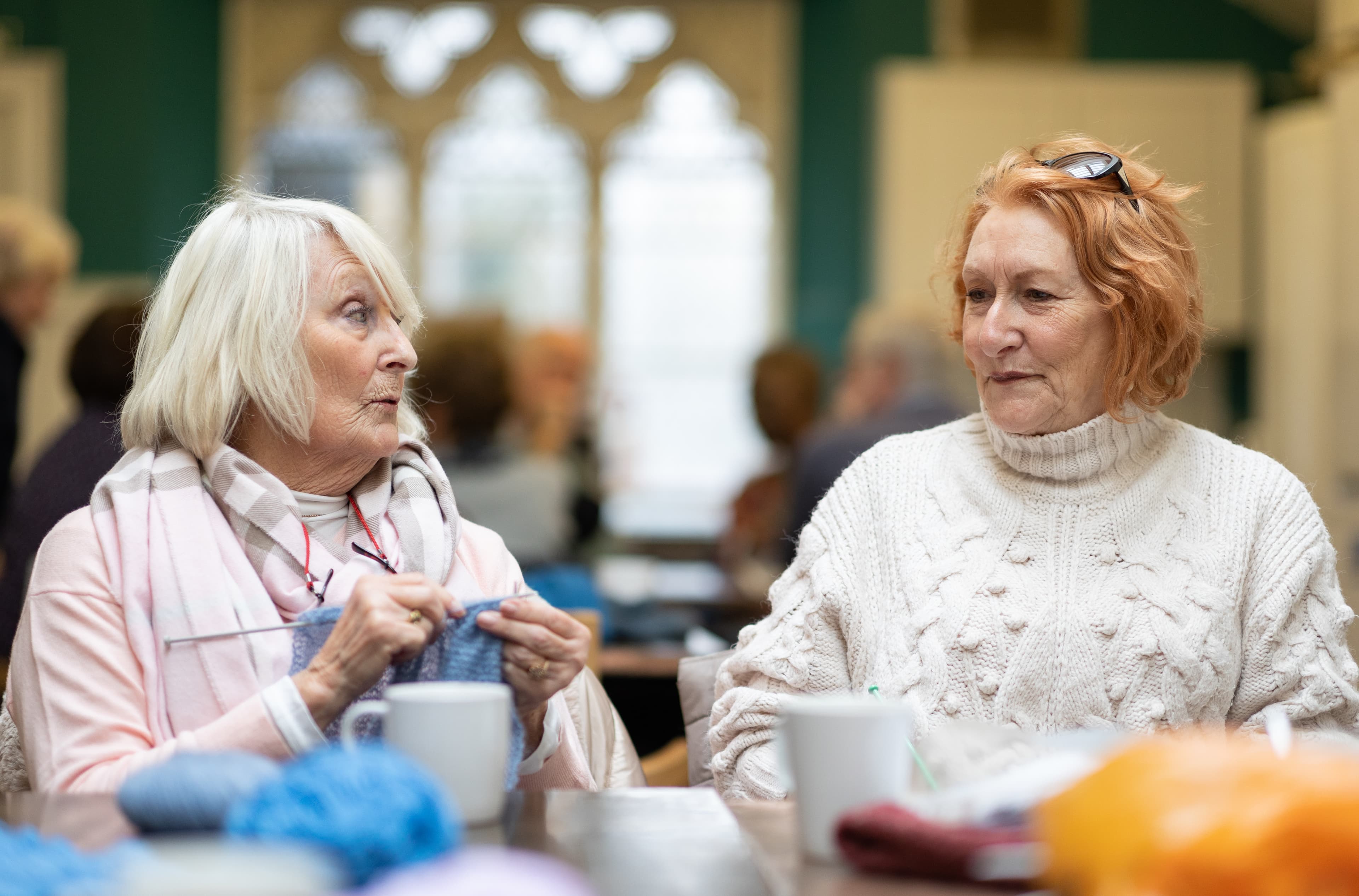 A friendly caregiver interacting warmly with an older woman